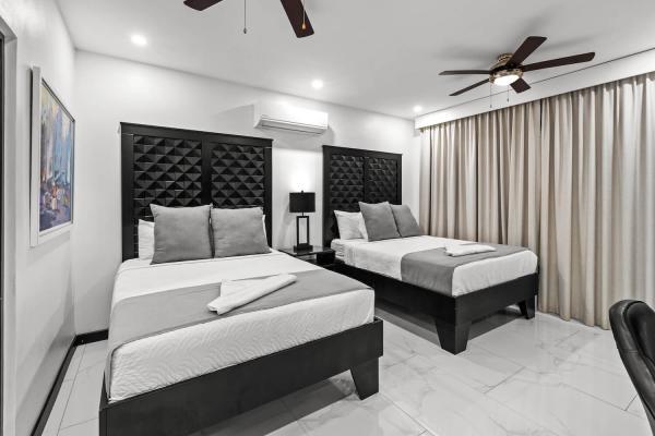 2 Queen Beds Inviting king bedroom with floor-to-ceiling drapes, tufted headboard, and a private ensuite bathroom, Jaco Beach