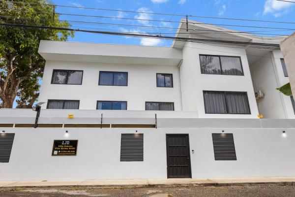 Striking three-story exterior facade of Villa Norma with modern white architecture, half a block from Jaco Beach