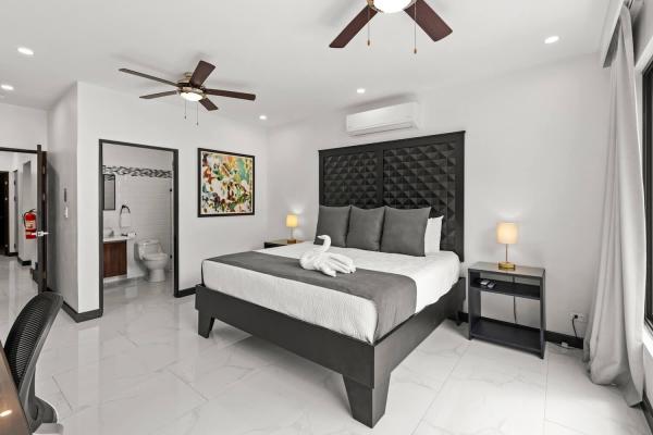 Spacious king suite with open ensuite bathroom, dual ceiling fans and air conditioning unit at Villa Roberto