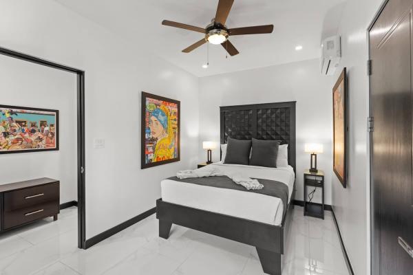 King bedroom with lush green garden view through window and bold pop art prints on the wall, Costa Rica