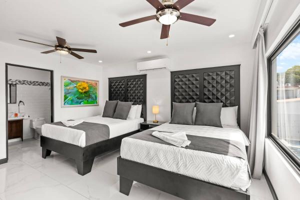 Double queen bedroom with direct ensuite bathroom, ceiling fan and AC unit, ideal for group vacation stays