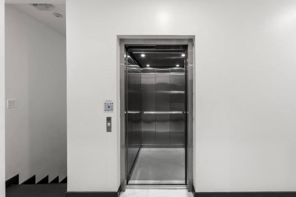 Interior of the private stainless steel elevator with mirrored cabin and recessed lighting, luxury villa Jaco