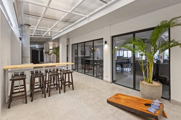Covered outdoor entrance patio with wood bar counter, barstools and tropical palms, Jaco vacation rental