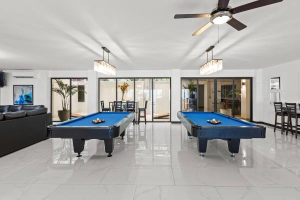 Dual pool tables with sliding glass doors opening to the outdoor pool terrace, Jaco vacation rental
