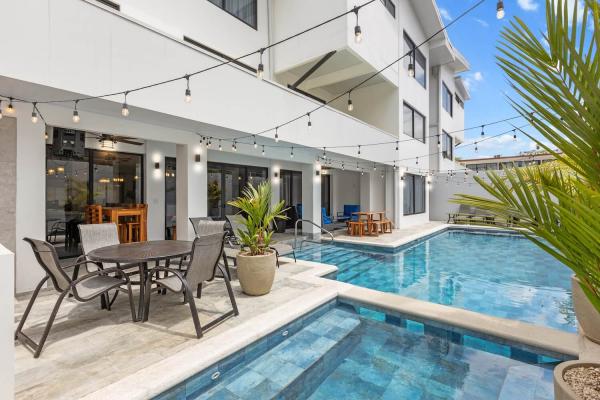 Outdoor al fresco dining terrace beside the private pool with string lights and tropical palms, central Jaco