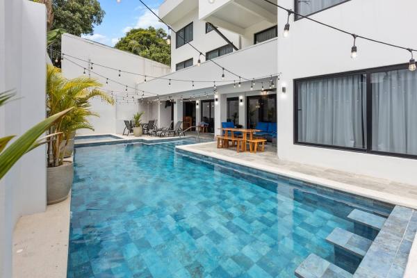 Three-storey modern villa exterior with pool terrace, outdoor dining furniture and string lights at Villa Roberto