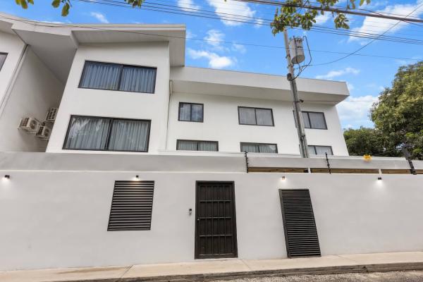 Villa Roberto modern three-storey white rendered villa exterior with iron gate entrance, central Jaco