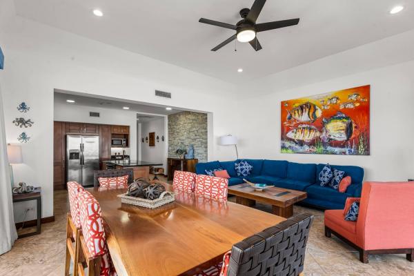 Living room with TV, red chair, wood coffee table, and coastal décor