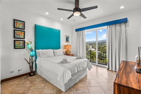 1 Queen Bed Bedroom 3 with queen bed, teal padded headboard, and wood furniture