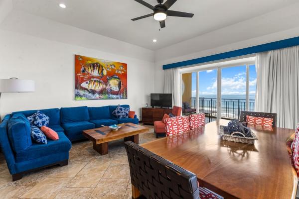 Living area with west-facing slider doors opening to panoramic ocean view
